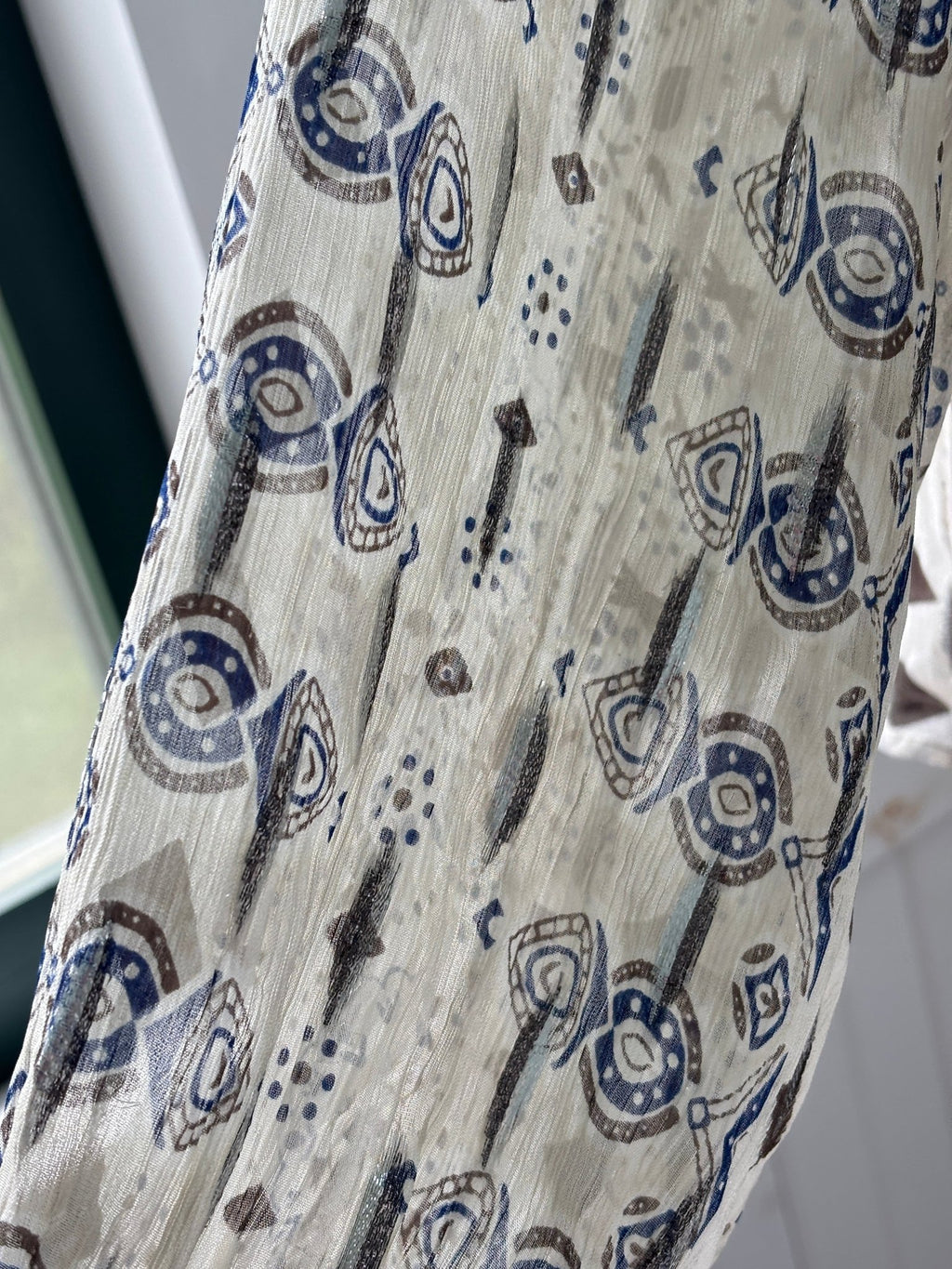 Close-up of navy and taupe block print fabric with silver metallic thread on Zara blouse