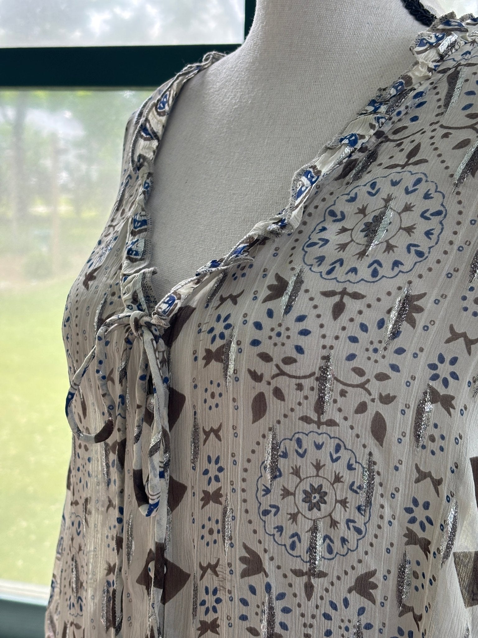 Close-up of ruffled V-neckline and self-tie closure on Zara ivory block print blouse